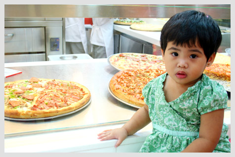 Tisay among pizzas